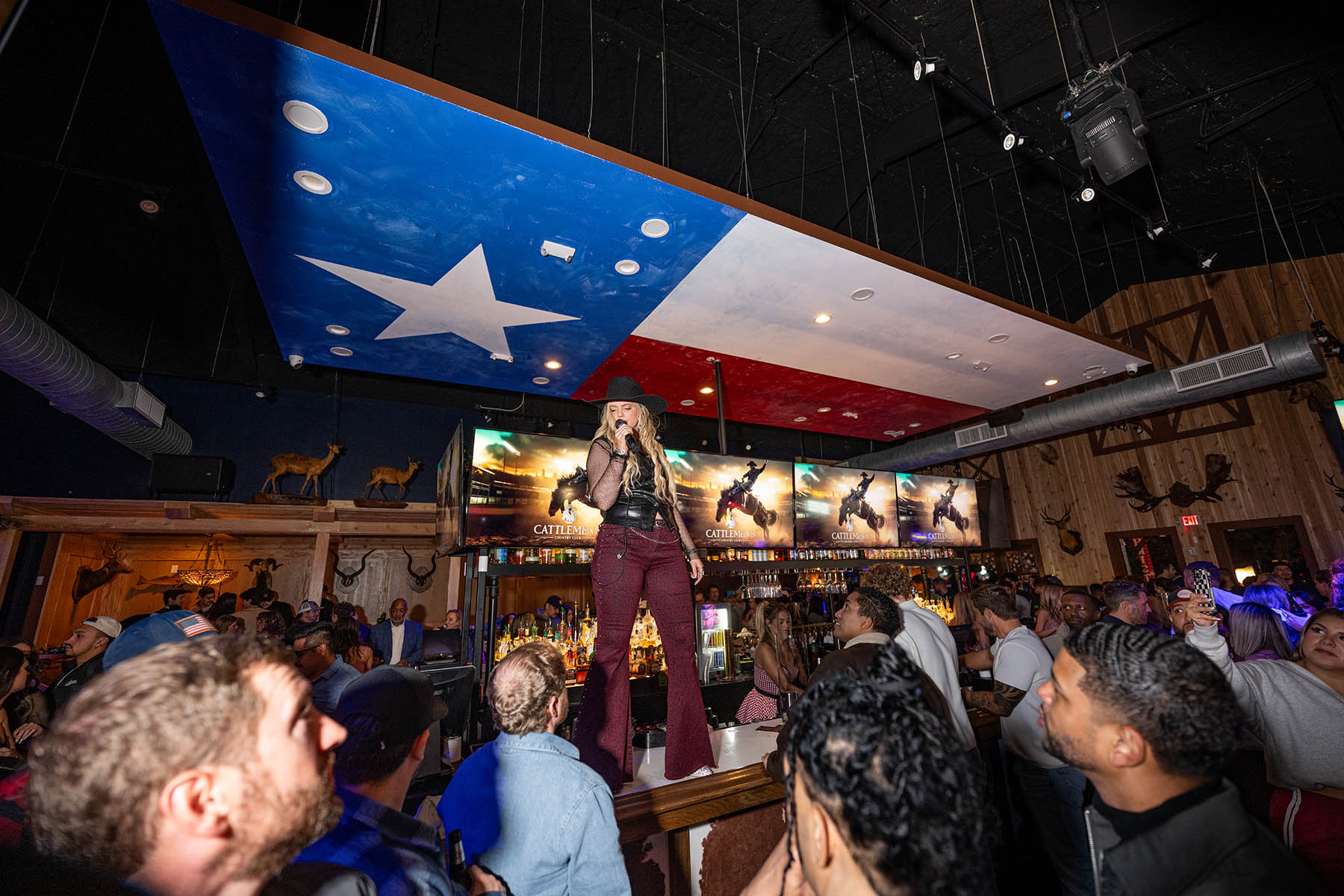 The Texas flag stretched across the ceiling above the stage at Cattlemen's Country Club