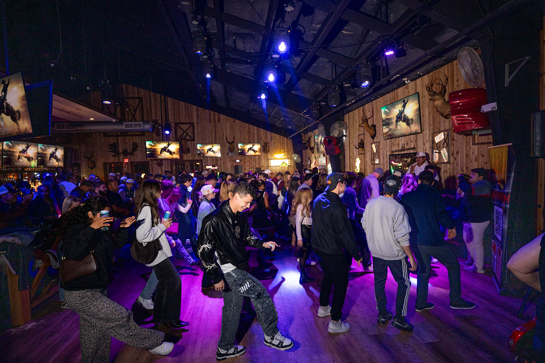 A packed night at Cattlemen's Country Club under purple lighting